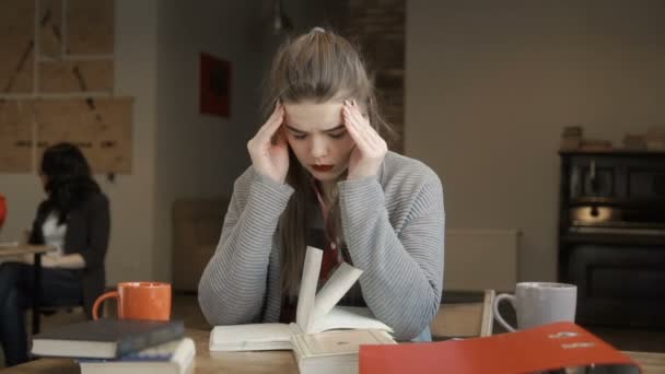 Втомилася і виснажена дівчина готується до іспитів в університеті — стокове відео