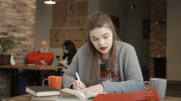 Pretty girl prepares to exams at university — Stock Video