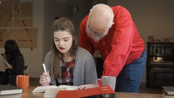 Älterer Mann hilft jungen Studenten, Hausaufgaben zu machen — Stockvideo