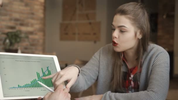Két fiatal üzletemberek megvitassák pénz növekedési üteme nézi a digitális tábla — Stock videók