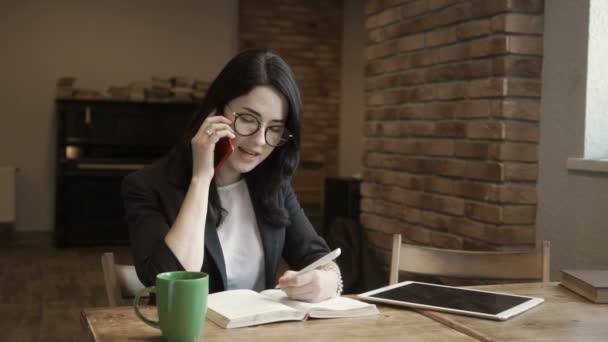 Молодая стильная женщина в очках разговаривает по телефону — стоковое видео