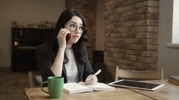Mladá podnikatelka mluví po telefonu a vypadá na obrazovce digitální tabletu — Stock video