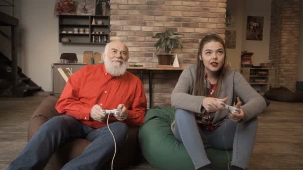 Senior man wint competitie in videospel in kleindochter — Stockvideo