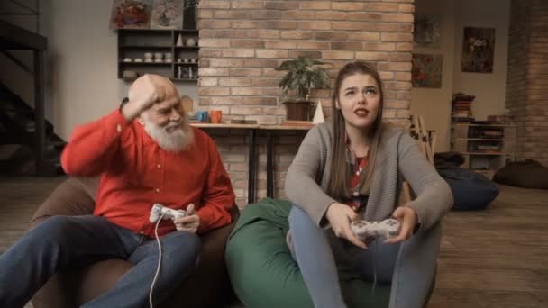Chica joven está molesta debido a su abuelo con la competencia en el videojuego — Vídeos de Stock