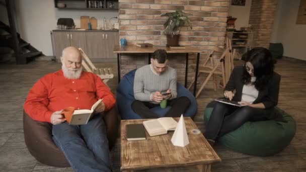 As pessoas estão trabalhando no espaço de coworking sentado em sacos de feijão — Vídeo de Stock