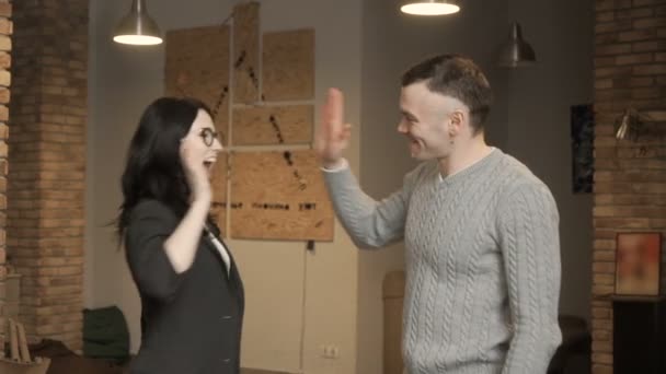 Ziemlich brünette high-five mit schöner Mann — Stockvideo