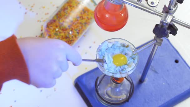 Kemist blanda blå steka ägg i en kolv i laboratorium, kemiska experiment — Stockvideo