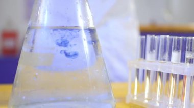 Kimyager bir şişe asit mavi madde koymak