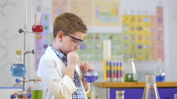 Молодой ученый проводит эксперимент с жидкостью в лаборатории — стоковое видео