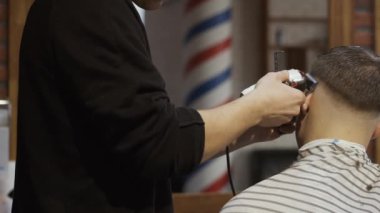 Tıraş olan genç bir adam için saç stilist yapar
