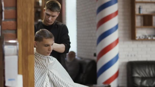 Professzionális fodrász tesz egy fiatal férfi frizura, elektromos borotva