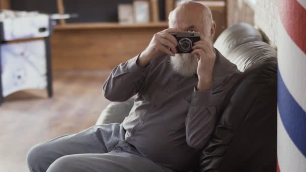 Starší muž fotografie něco s starý fotoaparát — Stock video