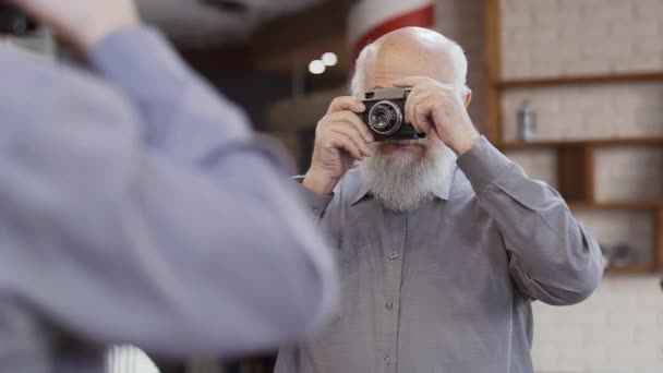 Schöner reifer Mann macht Selfie mit einer alten Kamera im Spiegel — Stockvideo