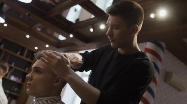 Profesyonel kuaför saç şekillendirme için genç adam berber içinde yapar.
