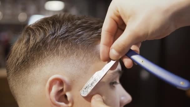 Cabeleireiro faz contorno ao penteado com lâmina afiada — Vídeo de Stock