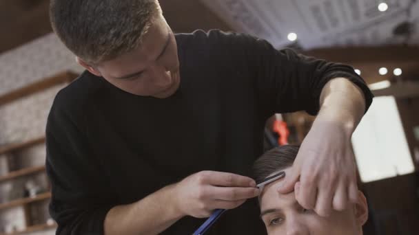 Estilista hace contorno a corte de pelo con cuchilla — Vídeo de stock