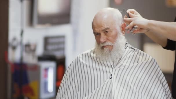 Professionell stylist gör frisyr till senior mannen — Stockvideo