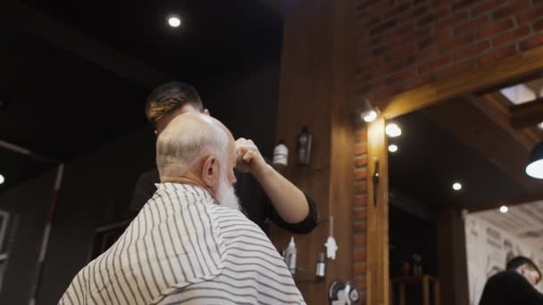 Hairdresser makes new hairstyle for senior man — Stock Video