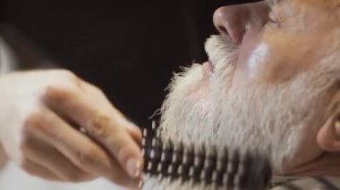 Kuaför kurur ve olgun adamın sakalı tarak