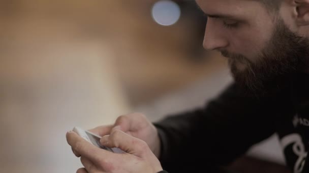 Bebaarde man maakt gebruik van telefoon — Stockvideo