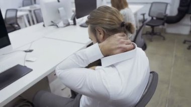 İşadamı ofiste çalışma sırasında boyun ağrısı var