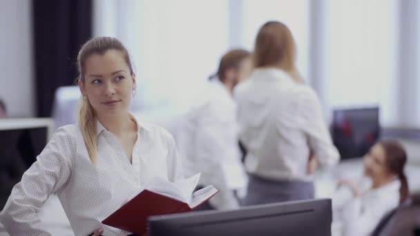 Красива бізнес-леді посміхається і фліртує зі своїм колегою в офісі — стокове відео