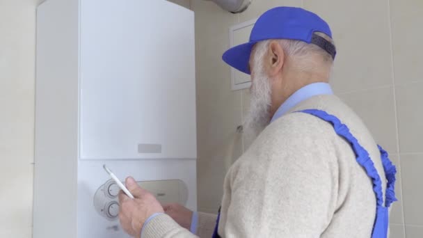 Viejo maestro ajustar la temperatura de la caldera con tableta digital — Vídeos de Stock
