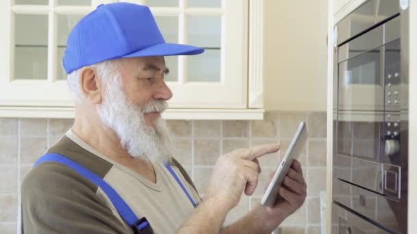 Senior man adjust oven using digital tablet and looking at camera — Stock Video