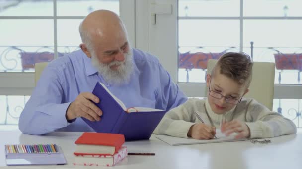 Opa mit Enkel macht gemeinsam Hausaufgaben — Stockvideo