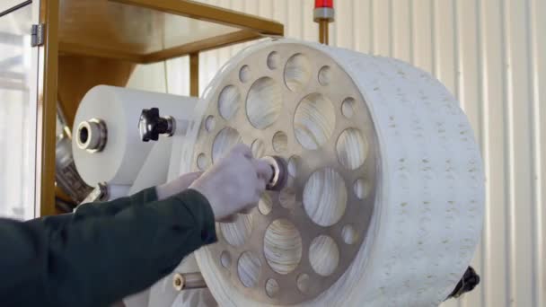 Travailleur enlève le papier utilisé pour l'emballage du thé de la machine à l'usine — Video