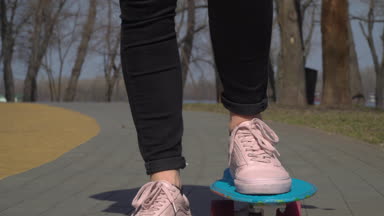 Kaykay ile şık kız telefonu kullanır ve lolipop elinde tutan