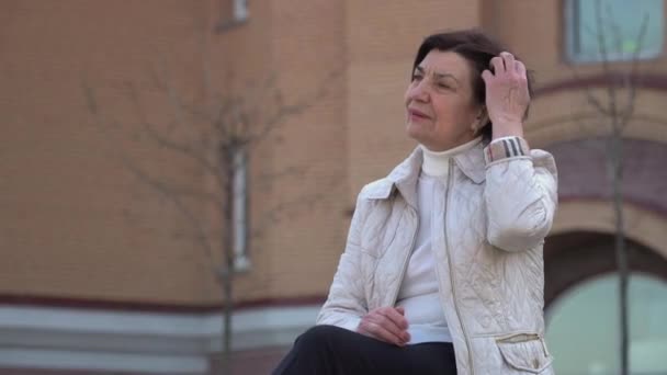 Mature woman relax on the bench in park — Stock Video