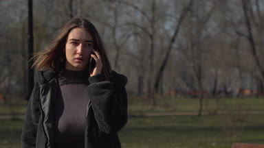 Genç kız görüşmeler Park'ta yürüyordunuz telefon