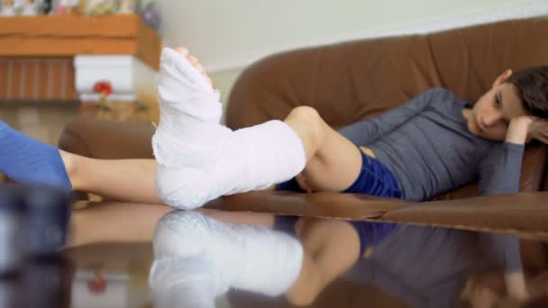 Μικρό αγόρι με σπασμένο πόδι είναι βαρετό στο σπίτι — Αρχείο Βίντεο