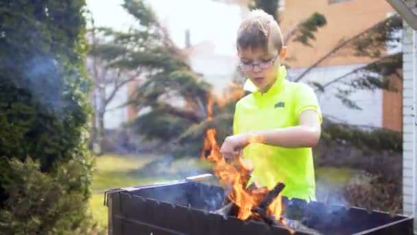 Gyermekek ideiglenes tákolmány tűz belül grill — Stock videók