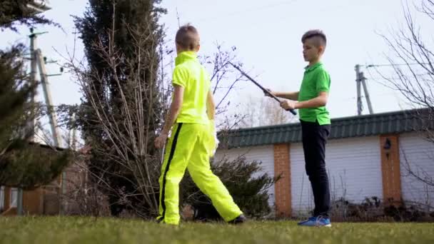 Pojke skär grenar på träd i trädgården — Stockvideo