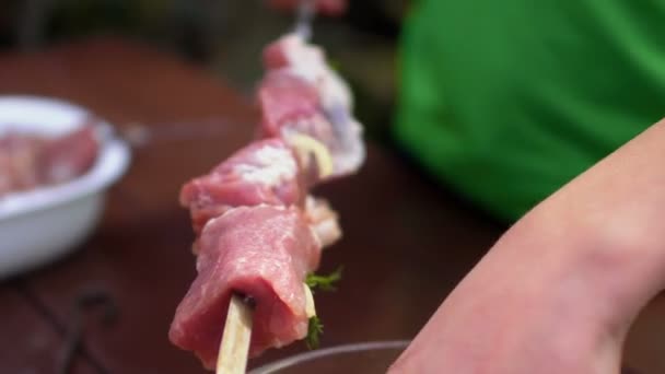 Garçon mettre de la viande marinée sur une brochette, gros plan — Video