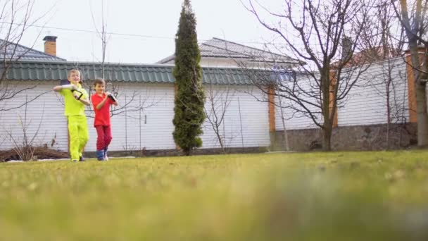 Des petits garçons avec des pelles se promènent dans un jardin — Video