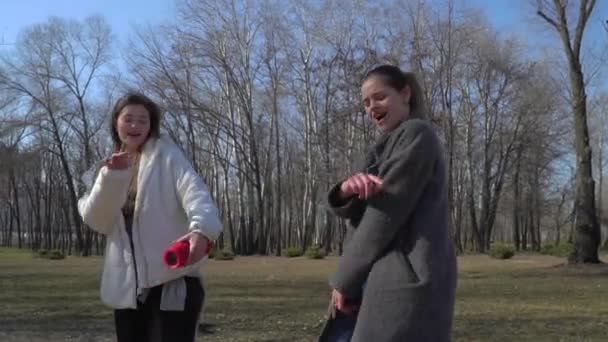 Δύο μοντέρνα κορίτσια χορεύει στη μουσική στο πάρκο — Αρχείο Βίντεο