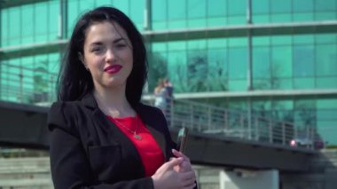 Gülümseyen esmer dijital tablet elinde tutmak ve kameraya benziyor