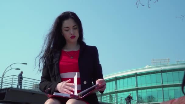 赤い唇と赤いドレスの美しい女性は、彼女のスケジューラ — ストック動画