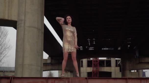 Όμορφη μελαχρινή χορεύουν στο φόντο της εγκαταλειφθεί γέφυρα — Αρχείο Βίντεο