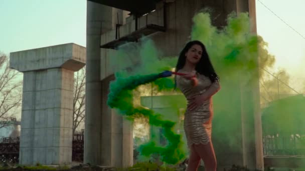 Красивая женщина в платье танцует с зеленым дымом — стоковое видео