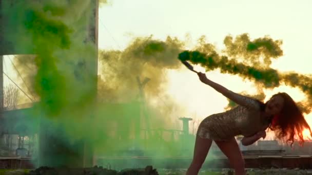 Hermosa morena en vestido bailando con humo verde en cámara lenta — Vídeos de Stock