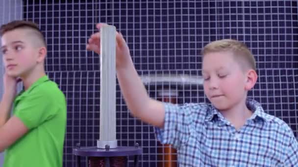 Jongen maakt experimenteren met elektromagnetische apparatuur in wetenschapsmuseum — Stockvideo