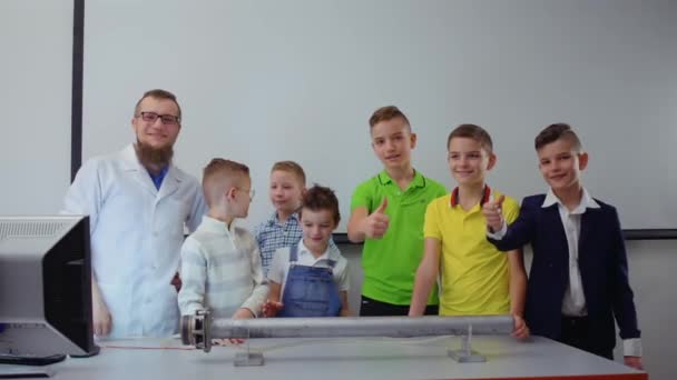 Kinderen en laboratorium assistent toont thumbs up camera — Stockvideo