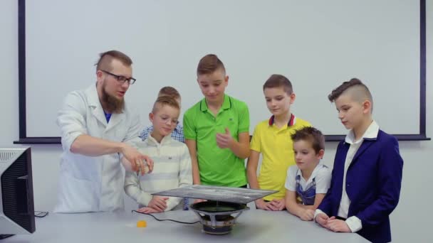 Лаборант показывает мальчиков танцующих песок на тарелке хладни — стоковое видео