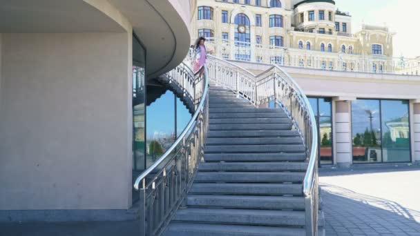 Mujer feliz se mueve hacia abajo en la escalera — Vídeo de stock