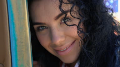 Güzel gülümseyen kıvırcık esmer yeşil gözlü