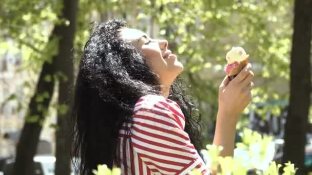 Morena comer helado en parque — Vídeos de Stock